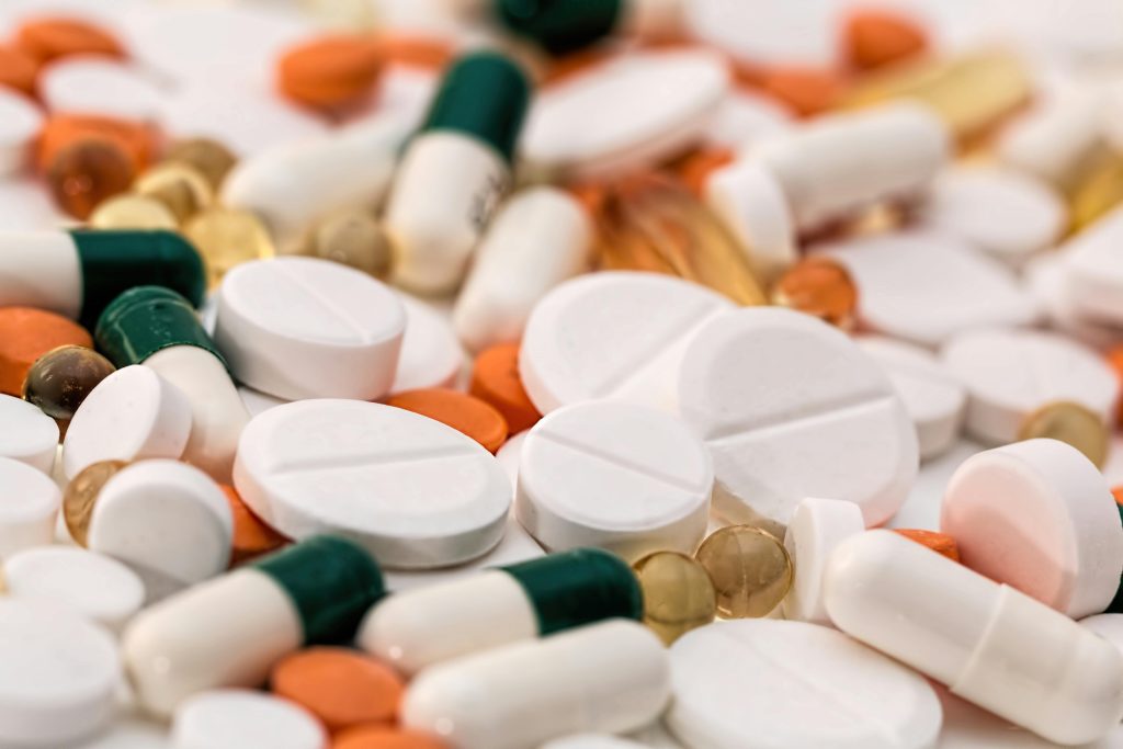 Close-up of various pills and capsules in different colors and sizes, ideal for healthcare-related content.