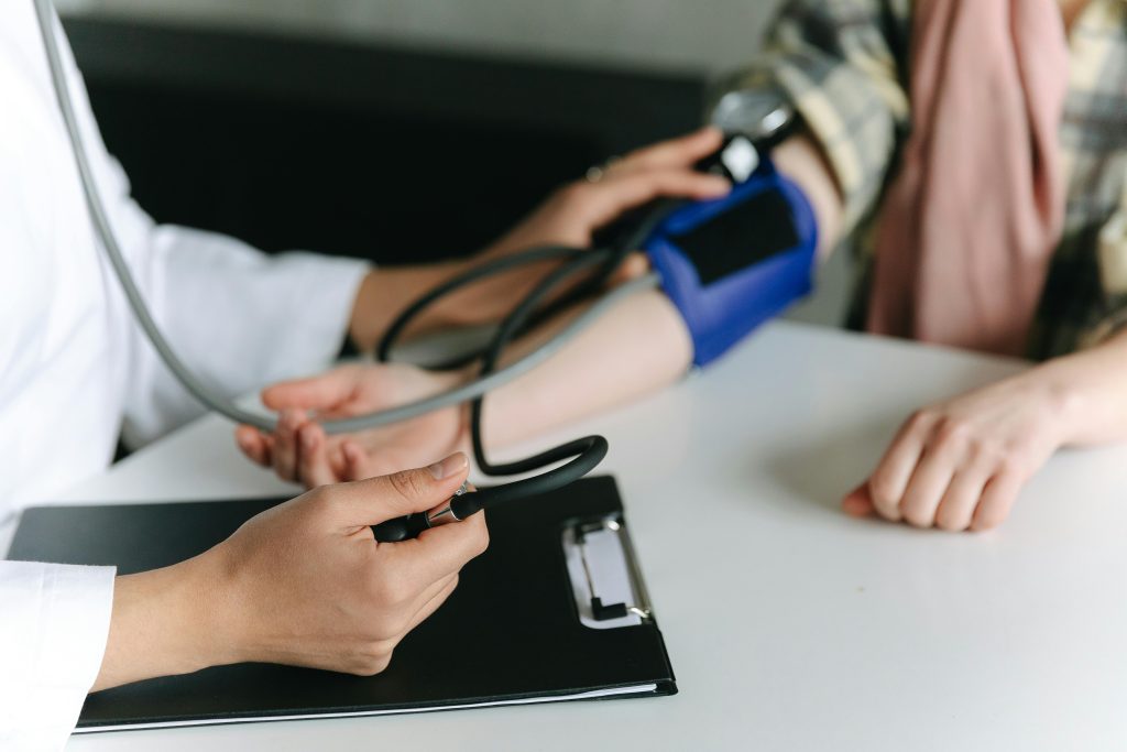 Close-up of a medical professional measuring a patient's blood pressure at a clinic.